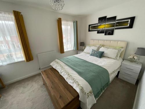 a bedroom with a large bed and two windows at Comet place in Wellingborough