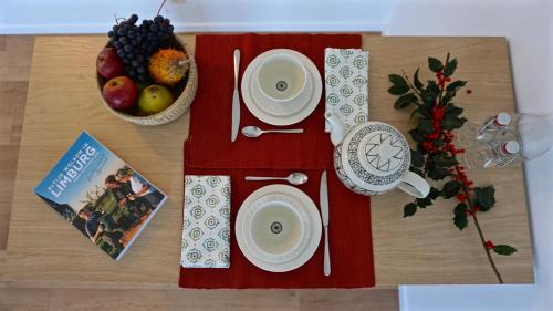 a table topped with a red table cloth with a plate of fruit at De Notelaar in Kortessem