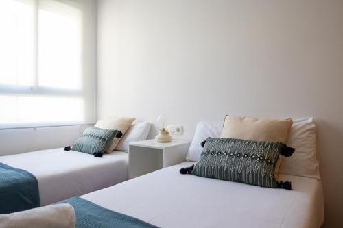 バレンシアにあるMedinaceli airco, wifi and free parkingの白い部屋で、ベッド2台、窓が備わります。