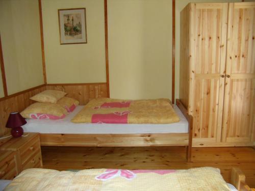1 dormitorio con 2 camas individuales y armario en Hipságh Vendégház en Hegykő