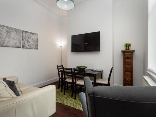 a living room with a couch and a dining room table at Apex Living NE - Beachville House 4 Beds FREE PARKING in Sunderland