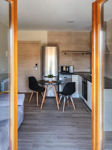 eine Küche mit einem Tisch und Stühlen im Zimmer in der Unterkunft DOMVS I in El Burgo de Osma-Ciudad de Osma