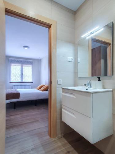 1 dormitorio con 1 cama y baño con lavabo. en DOMVS I en El Burgo de Osma