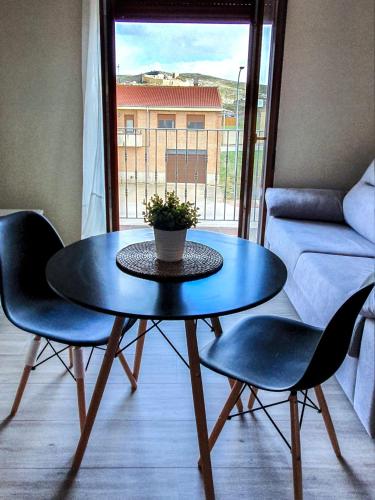 einen Tisch und Stühle im Wohnzimmer mit Fenster in der Unterkunft DOMVS I in El Burgo de Osma-Ciudad de Osma