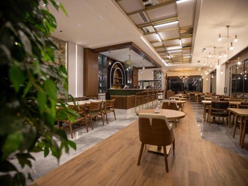 un restaurante con mesas y sillas y un bar en İncipark Hotel, en Sakarya