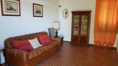 a living room with a brown leather couch and a table at Casina Margherita in Siena