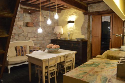 una cocina con mesa y sillas y una habitación con fregadero en Casa Antica en Castiglione dʼOrcia