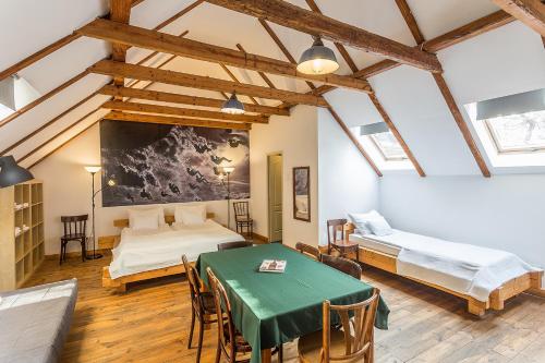 Cette chambre comprend 2 lits et une table verte. dans l'établissement Kőleves Fogadó, à Budapest