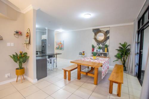 uma sala de estar com uma mesa e uma cozinha em Stay at The Point - Triumphant Tropical Tranquility em Durban