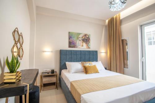 1 dormitorio con 1 cama con cabecero azul y mesa en Alcmene Lux Apartment by "elite", en Zakynthos