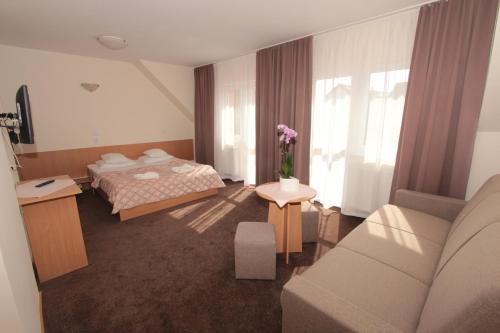 a hotel room with a bed and a couch at Sunset Przymorze in Rewal