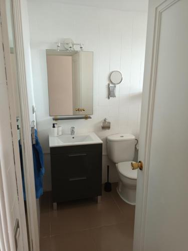 uma casa de banho branca com um lavatório e um WC em DAC HOME AGAETE PARQUE em Playa del Inglés