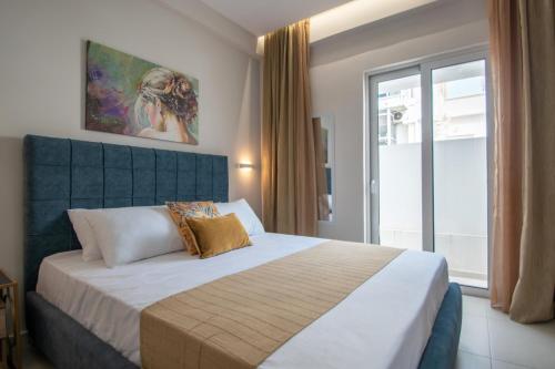 a bedroom with a large bed and a window at Alcmene Lux Apartment in Zakynthos Town