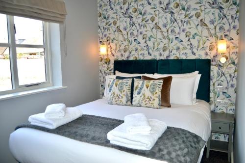 a bedroom with a bed with towels on it at The Nest Hotel & Restaurant in Petersfield