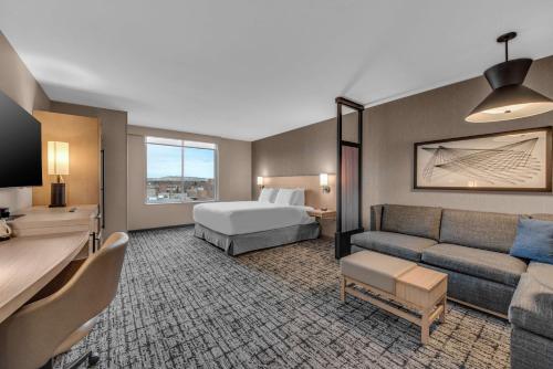 Habitación de hotel con cama y sofá en Hyatt Place Colorado Springs Downtown, en Colorado Springs