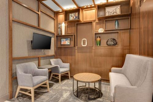 a waiting room with chairs and a flat screen tv at Hyatt Place Colorado Springs Downtown in Colorado Springs