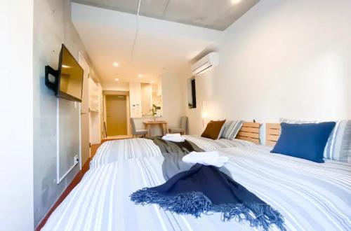 a bedroom with a large white bed with blue pillows at japan house nishishinjuku in Tokyo