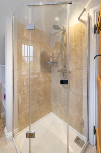 a shower with a glass door in a bathroom at White Cottage, Iken - Aldeburgh Coastal Cottages in Snape