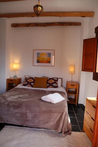 1 dormitorio con 1 cama grande y 2 mesitas de noche en Casa corasol, a cozy, comfy, 2BR house- panoramic view and rooftop, en Cáñar