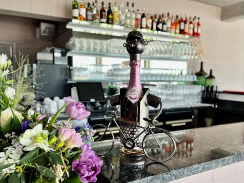 eine Flasche Wein und ein Fahrrad auf der Theke in der Unterkunft Zweirad Hotel Lenne in Schwerin