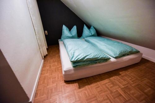 1 cama pequeña con almohadas azules en una habitación en SKYHIGH STUDIO STP, en Sankt Pölten