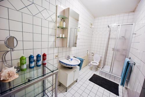 y baño de azulejos blancos con lavabo y ducha. en SKYHIGH STUDIO STP, en Sankt Pölten