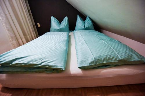 Una cama con almohadas azules encima. en SKYHIGH STUDIO STP, en Sankt Pölten