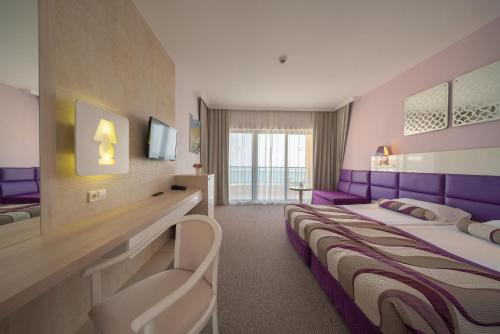 a hotel room with two beds with purple accents at Grifid Arabella Hotel - Ultra All inclusive & Aquapark in Golden Sands