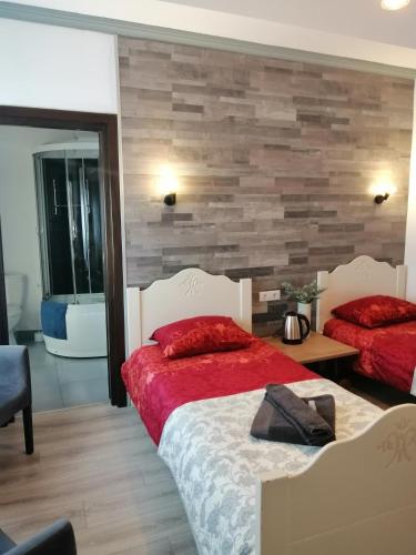 a bedroom with two beds and a wooden wall at Bizant Boutique in Bacău