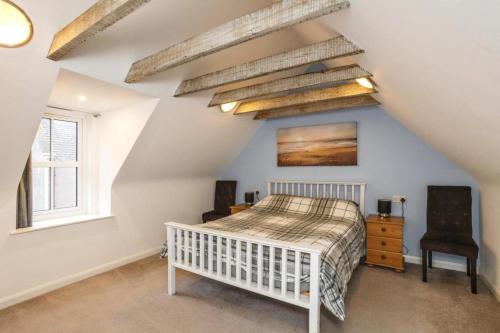 a bedroom with a white bed in a attic at 29 Seafield Street in Whitehills