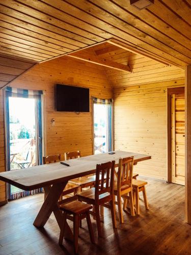 a large wooden table in a room with chairs at Wataha Zawóz in Polańczyk