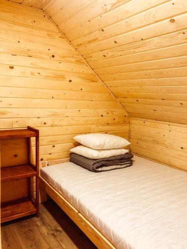 a cabin with a bed in a wooden room at Wataha Zawóz in Polańczyk