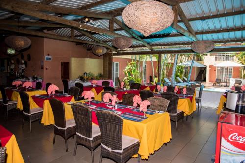 a banquet hall with yellow tables and chairs at La Margarita in Pointe aux Piments