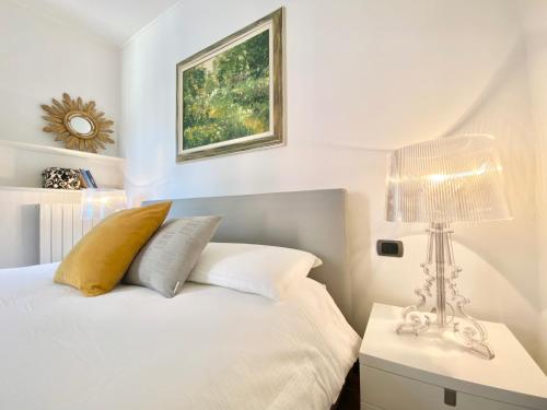 - une chambre blanche avec un lit et une lampe dans l'établissement CasaViva - Central Seaview Penthouse in Camogli, à Camogli
