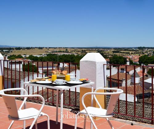 Una mesa y sillas en un balcón con vista. en Noble House Essence Évora - by Unlock Hotels, en Évora