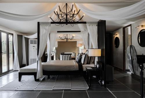 a bedroom with a canopy bed and a chandelier at The Alampara Resort - Luxury Boutique Glamping & Water sports in Cheyūr