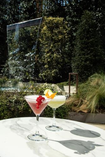 two cocktails sitting on a table in front of a fountain at Gold Tower Lifestyle Hotel in Naples