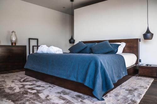 a bedroom with a large bed with a blue blanket at O Pouso dos Pousos in Mesão Frio