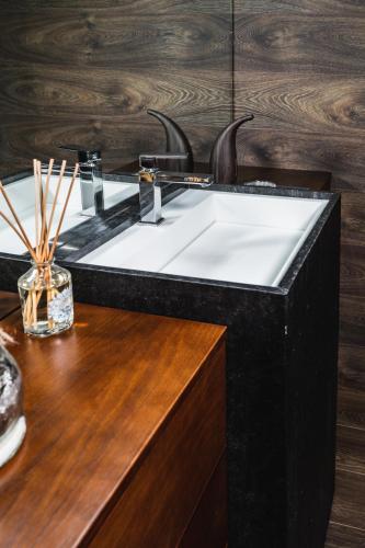 a bathroom with a black and white sink on a wooden counter at O Pouso dos Pousos in Mesão Frio