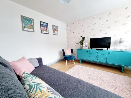 un soggiorno con divano blu e TV di Visit Seaford Apartment - 4 Bedrooms a Seaford