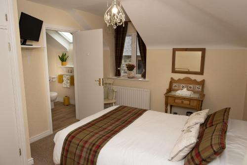 a bedroom with a white bed and a bathroom at Dromard House in Enniskillen