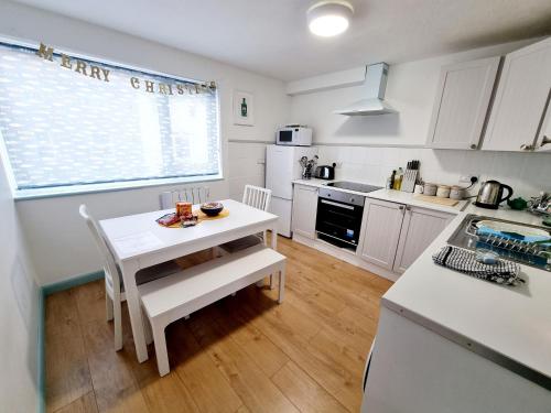 una cucina con tavolo bianco e piano di lavoro bianco di Visit Seaford Apartment - 4 Bedrooms a Seaford