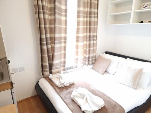 a small bedroom with a bed with a window at F204-Compact 2nd Flr Studio Fits 2-Near Hyde Park in London