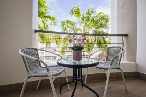a table and chairs on a balcony with palm trees at Marina Times Square Homestay by Evernent in Miri
