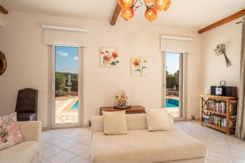 a living room with a couch and a view of a pool at Villa Emily in Fiskardho