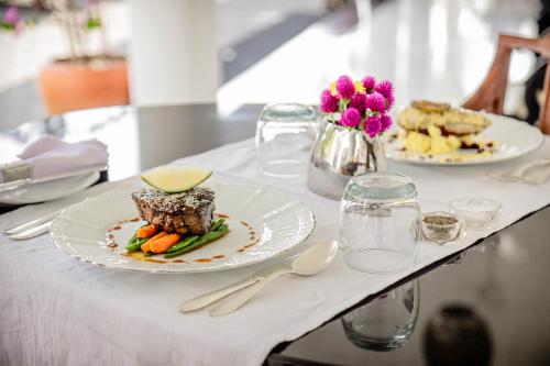 a table with two plates of food on it at The Flame Tree Estate & Hotel in Kandy