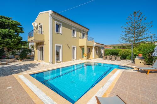 a villa with a swimming pool in front of a house at Villa Emily in Fiskardho