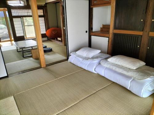 WE HOME STAY 川越的場 في كاواغويه: غرفة بسريرين جلوس في غرفة