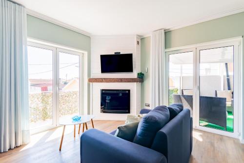 a living room with a blue couch and a fireplace at Bela Vista - Beach Apartment in Praia de Mira