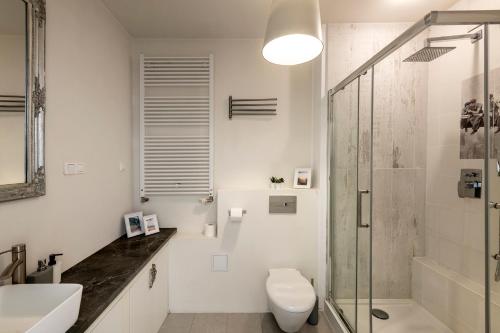 a bathroom with a shower and a toilet and a sink at Waw Apartamenty Wilanów Sarmacka in Warsaw